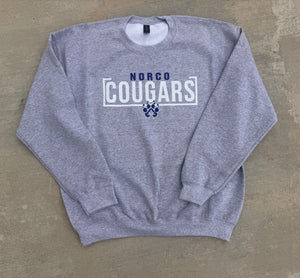 Gray sweatshirt with 'NORCO COUGARS' text and paw print on a beige background